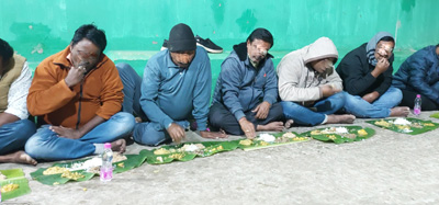 Devotees eating Mahaprasad while sitting on the floor